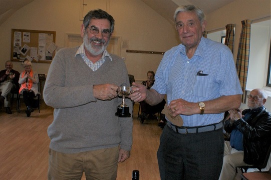 The winner Matthew receives the trophy from Bert